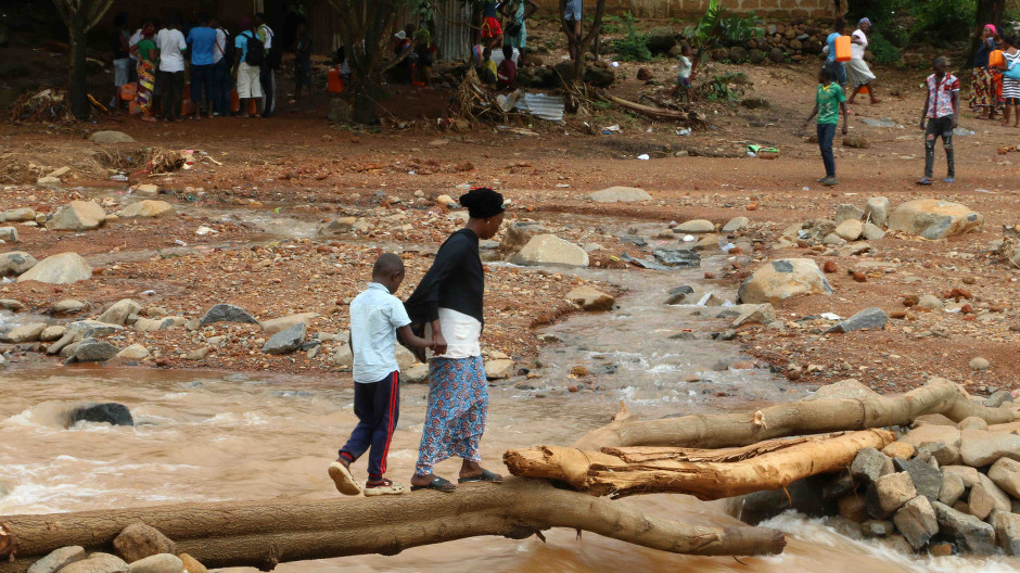 Image fo woman and child walking across flooded ground