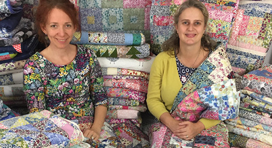 Alice and Anna with the quilts made by volunteers