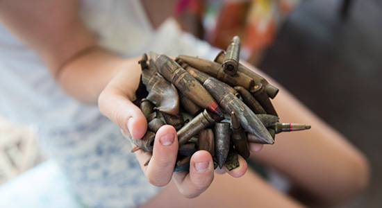 Child hand holding bullets 